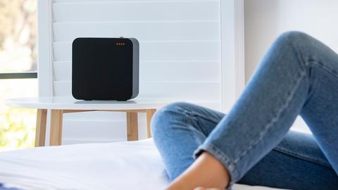 Der WLAN Lautsprecher steht in einem Schlafzimmer auf einem Beistelltisch.