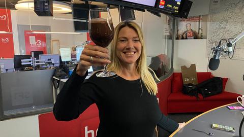 Tanja und Tobi halten lächelnd ein Glas mit einem schokobraunen Shake in den Händen.