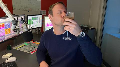 Tanja und Tobi halten lächelnd ein Glas mit einem schokobraunen Shake in den Händen.