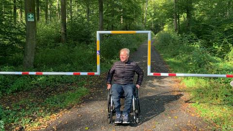 Frank Marasek fährt in seinem Rollstuhl unter seiner barrierefreien Schranke hindurch.