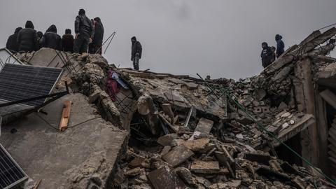 Syrische Zivilisten inspizieren ein zerstörtes Wohnhaus nach einem Erdbeben der Stärke 7,8 in Syrien. 