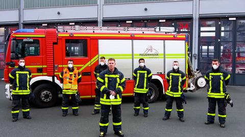 Die Männer der Feuerwehr Hanau steht vor einem ihrer Löschfahrzeuge